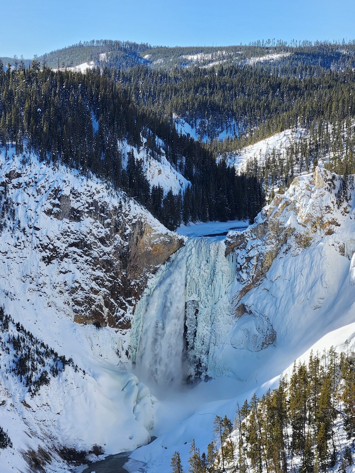 Lower Falls of the Yellowstone in winter with snow on the canyon walls